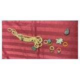 Broken beaded necklace and charms, and a ring that has interchangeable color bands