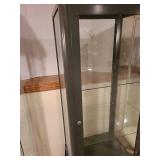 Metal and glass dark brown locking display cabinet, about 64x17x14, located in basement