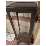 Metal and glass dark brown locking display cabinet, about 64x17x14, located in basement