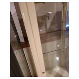 Metal and glass off-white locking display cabinet, about 64x17x14, located in basement