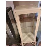 Metal and glass off-white locking display cabinet, about 64x17x14, located in basement