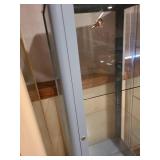 Metal and glass dusty blue locking display cabinet, about 64x17x14, located in basement