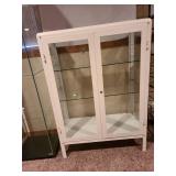 Metal and glass 2 door white locking display cabinet, about 44x32x16, located in basement