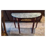 Half moon entry table with stone top 31x47x21.5 located in basement