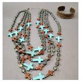 multi-strand beaded necklace with turquoise and wood crosses, paired with a copper brass cuff bracelet.
