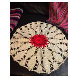 Collection of handcrafted textiles including embroidered linens, crocheted potholders, Rug and More