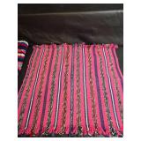 Collection of handcrafted textiles including embroidered linens, crocheted potholders, Rug and More