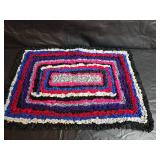 Collection of handcrafted textiles including embroidered linens, crocheted potholders, Rug and More
