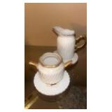 This is a Formalities by Baum Bros miniature white with gold trim tea set, made of bone china.