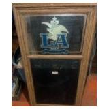 This is a vintage 1985 Anheuser-Busch LA Beer advertising mirror with a chalkboard.