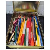 Pens and pencils in tins
