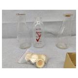 Three glass milk jugs left is flint and 18 caps