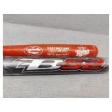 Two bats  red one is wood, Black is metal