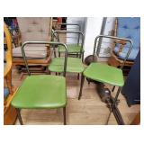 Four green folding chairs