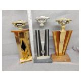 Three old automobile trophies