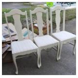 Three white chairs with cushion seats