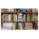 Two shelves of books on weaving, cookbooks and