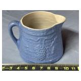 stoneware pitcher with a blue glaze and an
