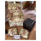 Floral rocking chair with stains and a tear in