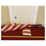 Two American flags one on wooden flag pole