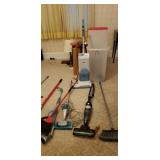 Brooms, vacuum , wrapping paper container, shovel