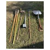 Shovels, rake, post whole digger and bracket on