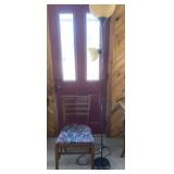 Tall floor lamp and padded wooden chair