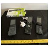 Three flip phones with one charger