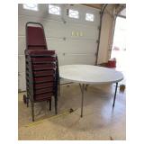5 foot round table with 8 padded chairs and roll