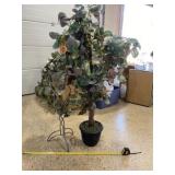 Artificial tree and iron and glass vase decor.