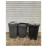 Three empty trash cans on wheels two with kids.