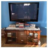 LG 42 inch tv mounted on tv stand with vhs tapes