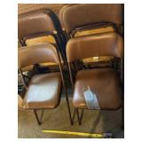 Six cushioned fold up chairs some with tears .