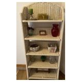 Wicker shelf with contents of vases and pictures.