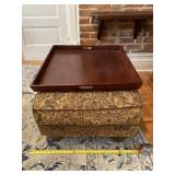 Tapestry foot rest with wooden tray.