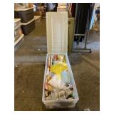 Tote with lid full of wrapping paper and ribbons.