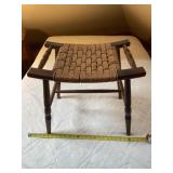 vintage dark-stained wood stool with a handwoven