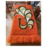 hand-tufted peacock wall hanging with a vibrant