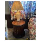 Lamp and round wooden night stand .