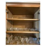 All glass ware on three shelves in cabinet
