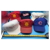Variety of ball caps including Cubs, American