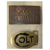 Two Colt revolver belt buckles.