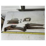 rusty tools including a large pipe wrench,
