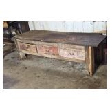 Old 7 ft wood workbench with three drawers.