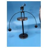 Kinetic balancing metal sculpture, often referred