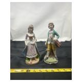 pair of porcelain figurines depicting a man and a