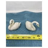 White ceramic swan figurines.
