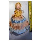 Vintage doll with colorful dress with sleepy eyes