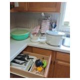 Crock pot, dish strainer and silverware.