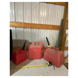 Two 5 gallon and a 2 gallon gas jugs.